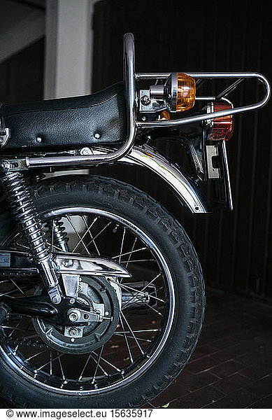 Hinterrad eines in der Garage abgestellten Oldtimer-Motorrads