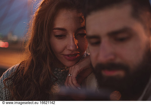 Hipster-Mann zeigt seiner Freundin sein Smartphone
