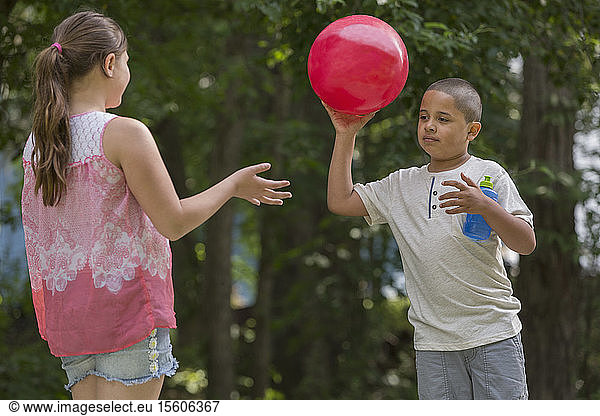 Hispanic boy with Autism playing outside with his sister