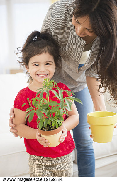 Hispanic mother and daughter gardening together