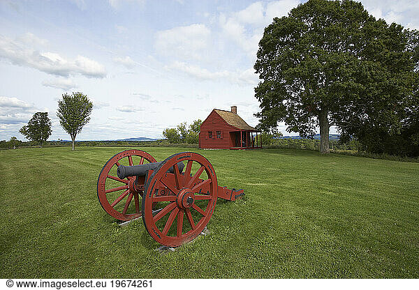 HIstoric battlefield with a red canon in the middle in Saratoga  New York.