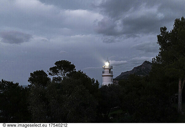 Historic Far des Cap Gros by silhouette trees at night,  Mallorca,  Balearic Islands,  Spain
