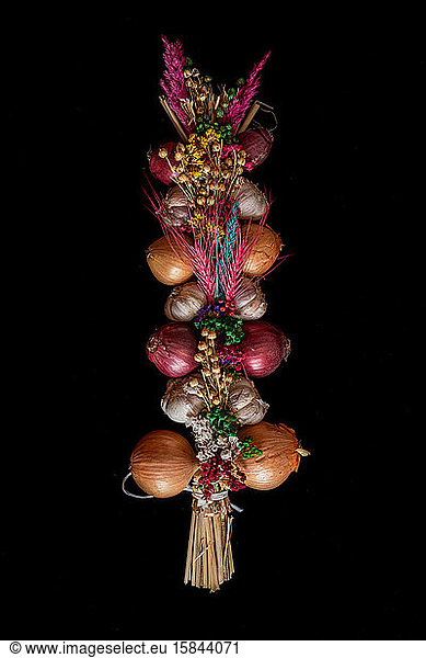 historical tie of onions and garlic with flowers and colorful grass to