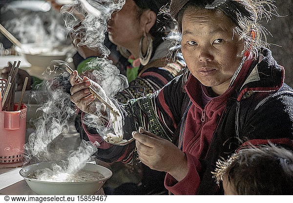Hmong-Stammesfrau isst dampfende Nudelsuppe