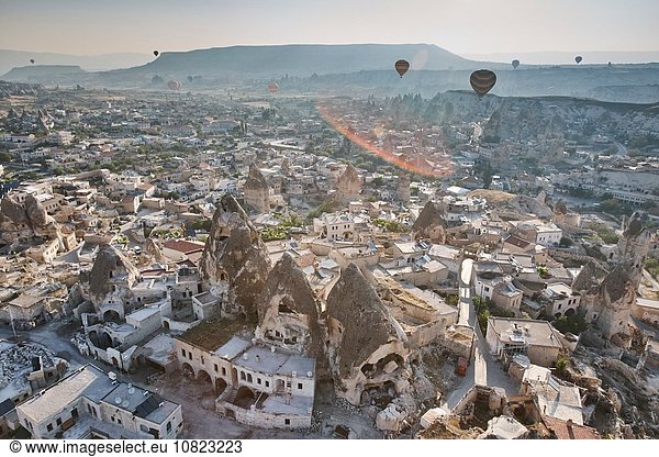 Hochansicht von Heißluftballons über Felsformationen und Behausungen Kappadokien Anatolien Türkei