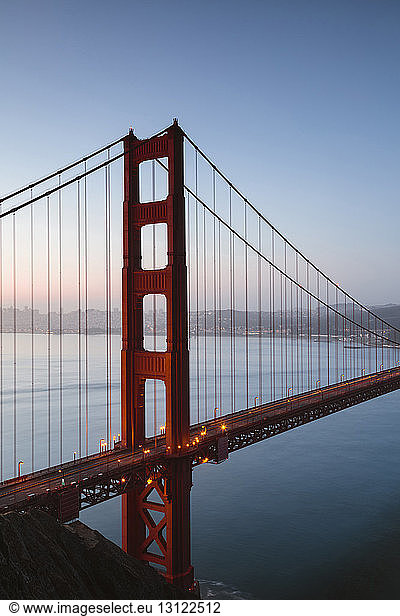 Hochwinkelansicht der Golden Gate Bridge über das Meer bei Sonnenaufgang