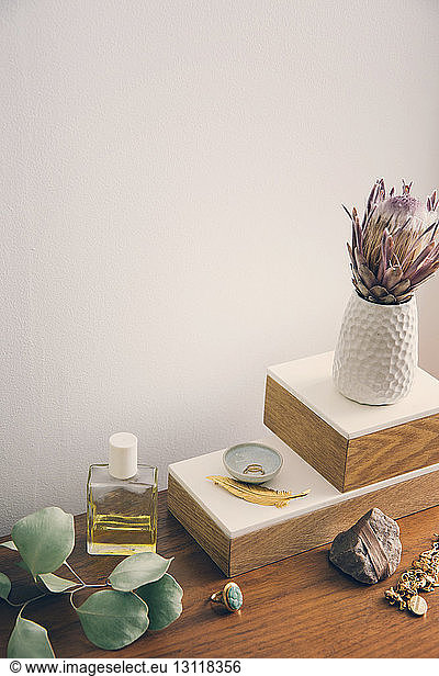 Hochwinkelansicht einer Blumenvase mit auf dem Tisch arrangiertem Schmuck- und Schönheitsprodukt