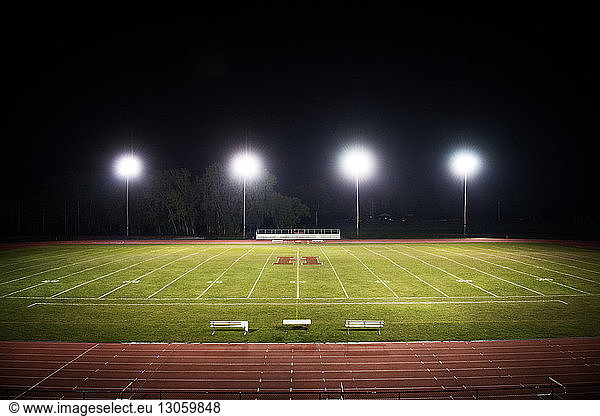 Hochwinkelansicht eines beleuchteten American-Football-Feldes bei Nacht