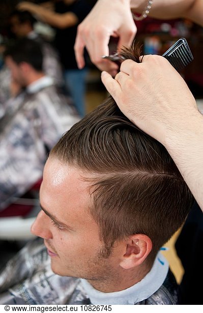 Hochwinkelansicht eines jungen Mannes im Friseursalon mit Haarschnitt