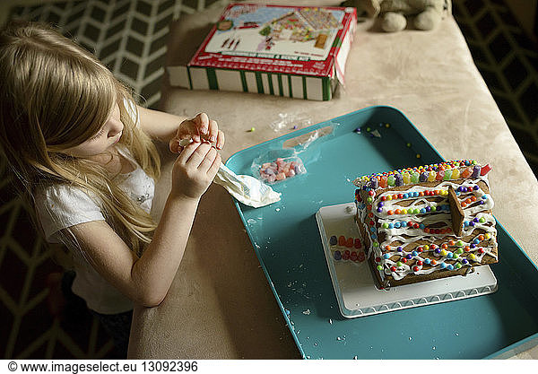 Hochwinkelansicht eines Mädchens beim Dekorieren eines Spielzeughauses
