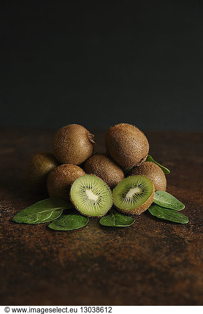 Hochwinkelansicht von Kiwifrüchten auf dem Tisch vor schwarzem Hintergrund