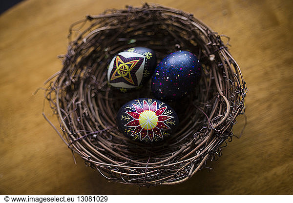 Hochwinkelansicht von Ostereiern im Nest auf Holztisch
