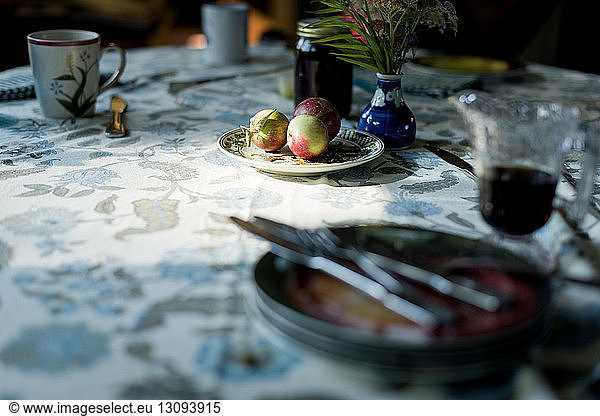 Hochwinkelansicht von Äpfeln mit Tellern  Besteck und Getränken auf dem Esstisch