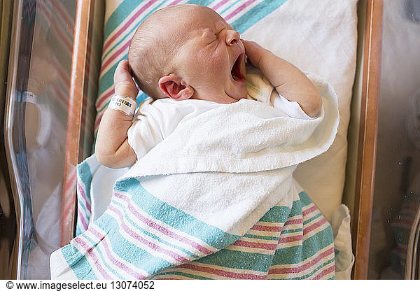 Hochwinkelaufnahme eines kleinen Jungen im Inkubator eines Krankenhauses