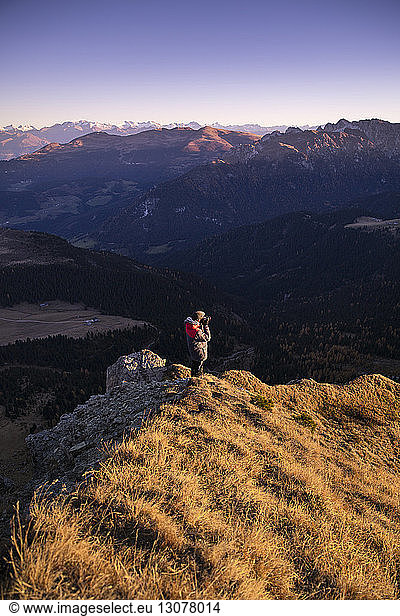 Hochwinkelaufnahme eines Mannes  der auf einem Berg stehend gegen den Himmel fotografiert