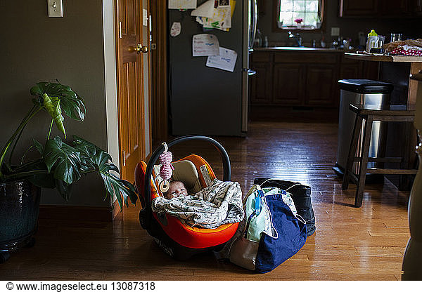 Hochwinkelaufnahme eines Neugeborenen  der zu Hause mit seinem Gepäck im Kindersitz ruht