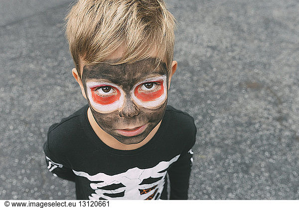 Hochwinkelporträt eines Jungen mit Gesichtsbemalung an Halloween