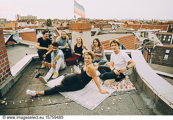 Hochwinkelporträt von Freunden  die sich während einer Party auf einer Terrasse in der Stadt entspannen