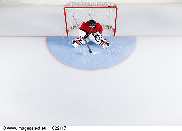 Hockeytorwart in roter Uniform zum Schutz des Tornetzes