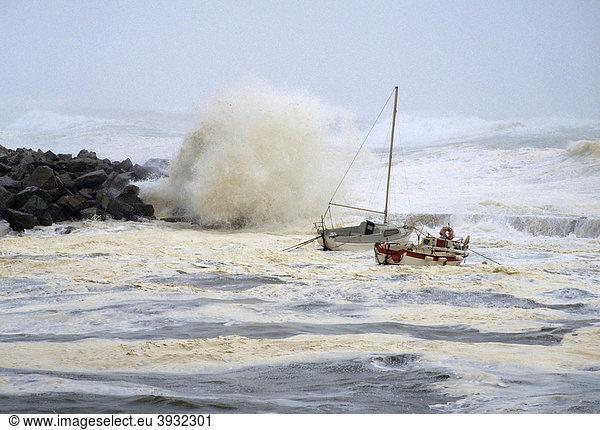 Hohe Wellen schlagen über Felsen  kleine Boote schaukeln  stürmische See an der bretonischen Küste  Orkan  FinistËre  Bretagne  Frankreich  Europa