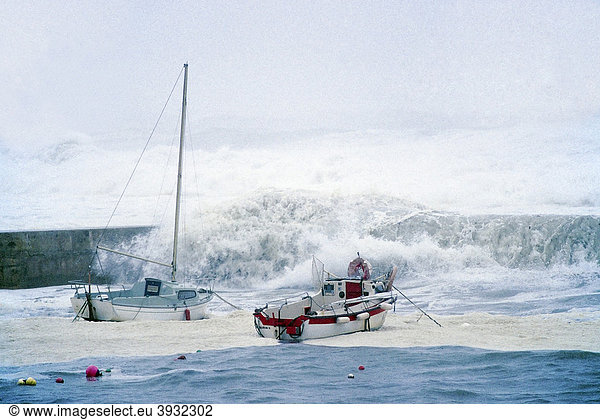 Hohe Wellen schlagen über Hafenmauer und kleine Boote  stürmische See an der bretonischen Küste  Orkan  FinistËre  Bretagne  Frankreich  Europa Wellen brechen