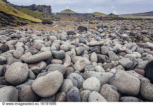 Hoher Felsrücken namens Valahnukamol neben dem Berg Valahnukur auf der südlichen Halbinsel Reykjanesskagi  Island  mit dem Leuchtturm von Reykjanes im Hintergrund.