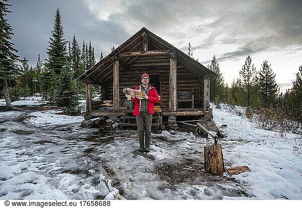 Holding chopped wood at Snow Peak Cabin in Colville National Forest