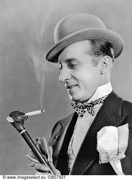 Hollywood  Kalifornien: 1927 Schauspieler Raymond Hatton mit einem Zigaretten rauchenden Affenkopf-Stock im Film ´Fashions For Women´.