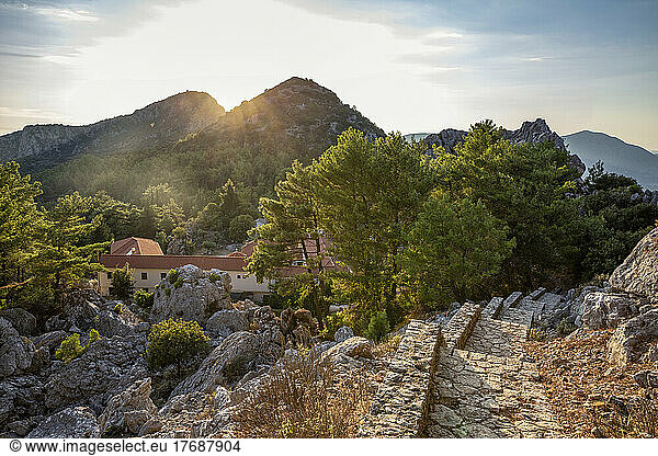 Holy Monastery of Agios Dimitrios amidst mountains at sunset
