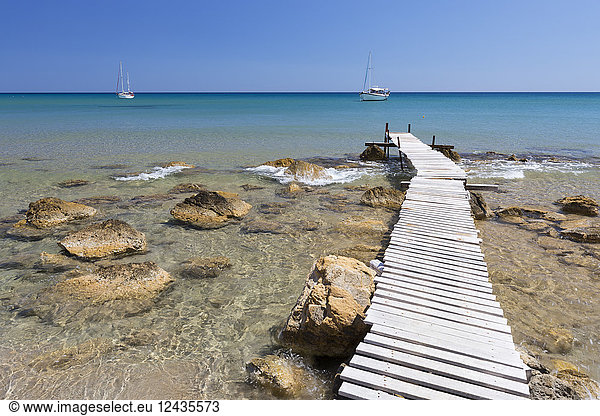 Holzsteg und klares türkisfarbenes Meer mit Yachten am Strand von Provatas  Milos  Kykladen  Ägäisches Meer  Griechische Inseln  Griechenland  Europa
