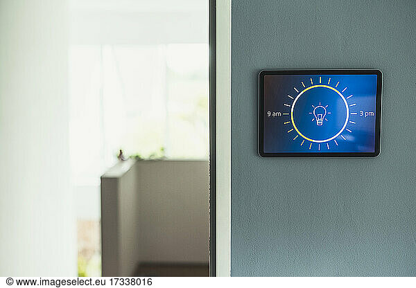 Home automation with light bulb icon on screen mounted on wall at home