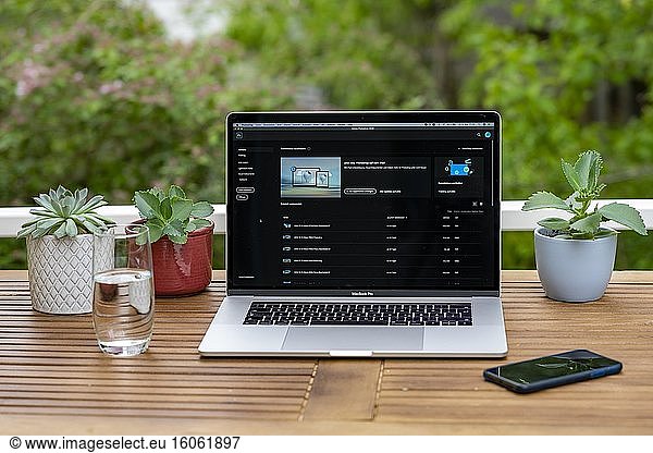 Home office with laptop  Apple MacBook Pro with iPhone X at your desk  with Adobe Photoshop application when editing photos  Germany  Europe