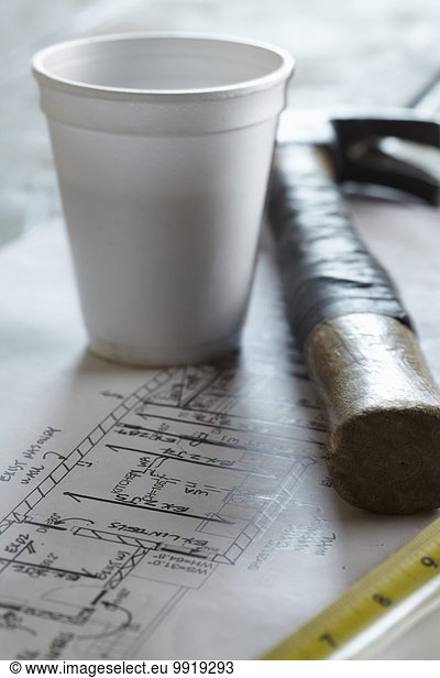 Home Renovation Still Life with Hammer  Blueprint  Styrofoam Coffee Cup and Tape Measure