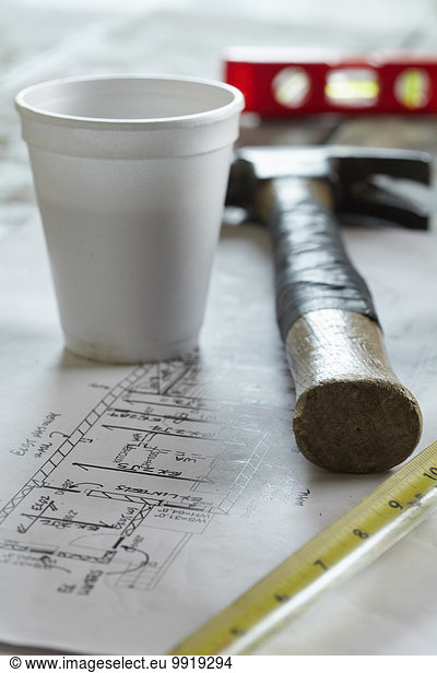 Home Renovation Still Life with Hammer  Blueprint  Styrofoam Coffee Cup  Tape Measure and Level