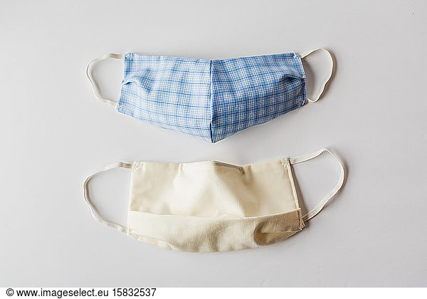 Homemade cloth face masks used during Covid-19 on white backdrop.