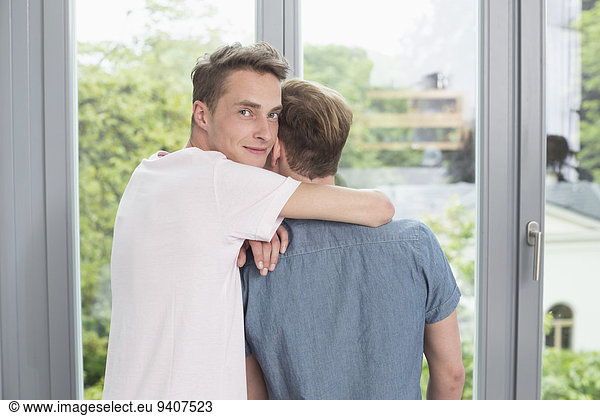 Homosexual couple embracing each other  smiling
