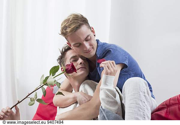 Homosexual couple with red rose