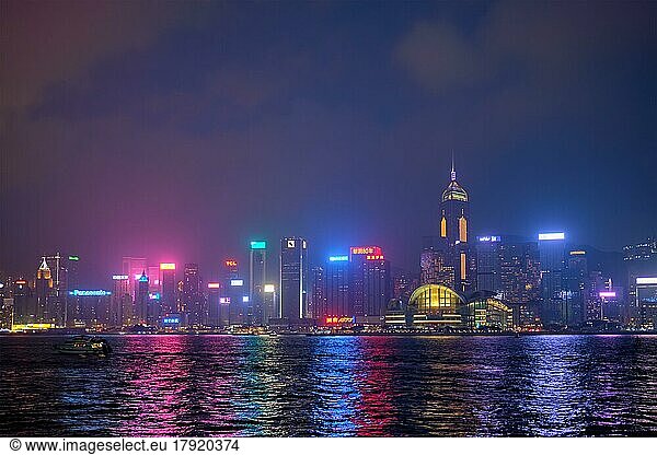 HONG KONG  CHINA  APRIL 28  2018: Hong Kong skyline cityscape downtown skyscrapers over Victoria Harbour in the evening illuminated with tourist boat ferries  Hong Kong  China  Asia