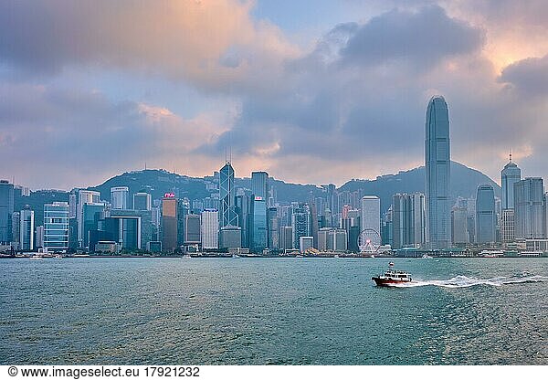 HONG KONG  CHINA  APRIL 28  2018: Hong Kong skyline cityscape downtown skyscrapers over Victoria Harbour in the evening on sunset with junk tourist boat ferries  Hong Kong  China  Asia