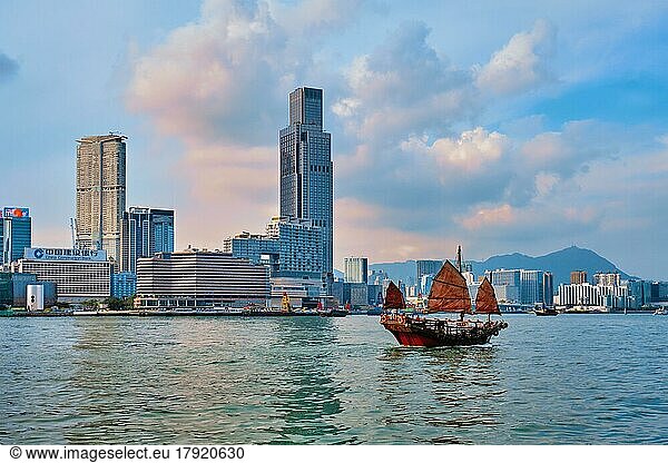 HONG KONG  CHINA  MAY 1  2018: Hong Kong skyline cityscape downtown skyscrapers over Victoria Harbour with tourist junk boat on sunset. Hong Kong  China  Asia