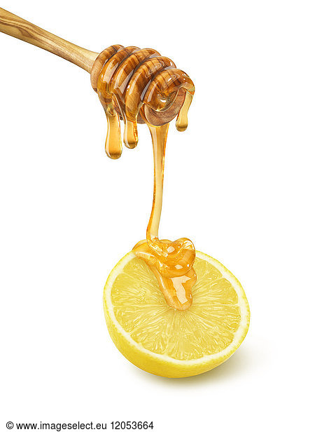 Honig tropft aus einer Schöpfkelle auf eine halbe Zitrone auf einem weißen Hintergrund