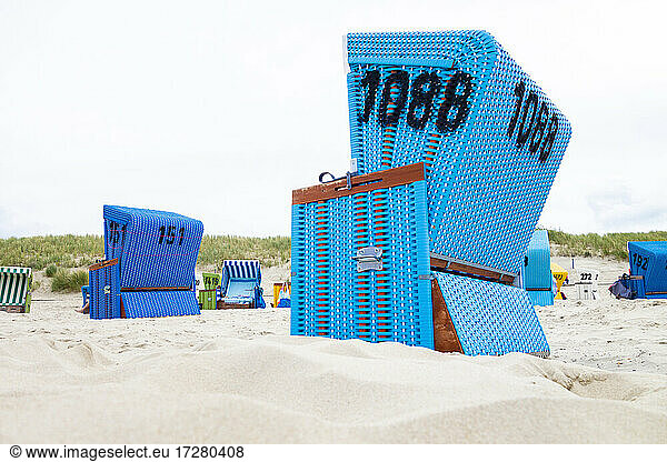 Hooded beach chairs on sandy coastal beach of Langeoog island