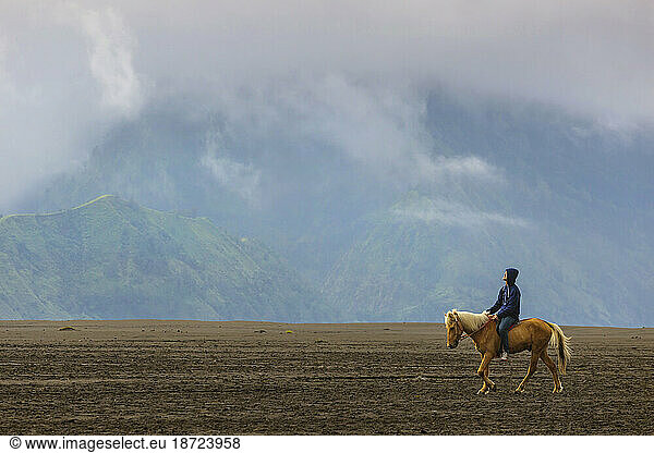 Horse riders near Mt.Bromo in early morning.Java.Indonesia