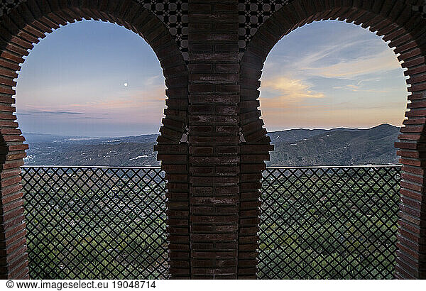 Horseshoe arched window at Comares village. Pueblo blanco up on