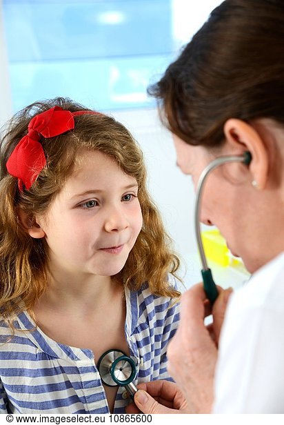 Hospital doctor examining a girl's chest with a stethoscope