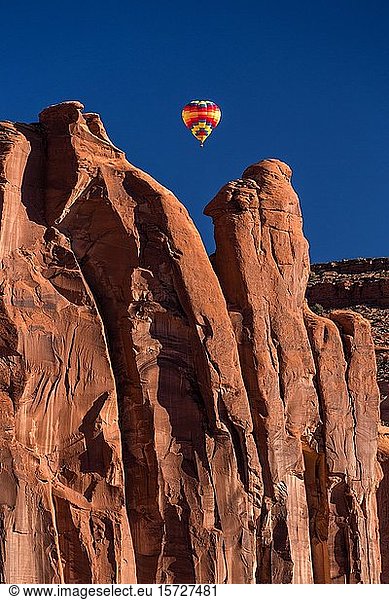 Hot air balloon flying between buttes  Balloon Festival in the Monument Valley  Monument Valley Navajo Tribal Park  Arizona  USA  North America