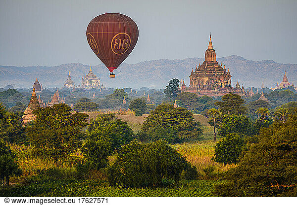 Hot air balloon in the air above a temple in Mandalay.