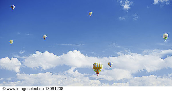 Hot air balloons flying in cloudy sky
