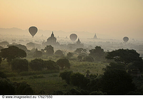 Hot air balloons hovering in the air above the plain of temples in Mandalay