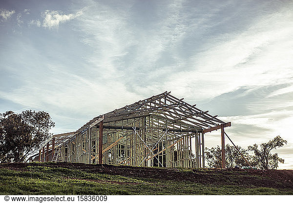 House frame on construction site stands on hill as farm gets build